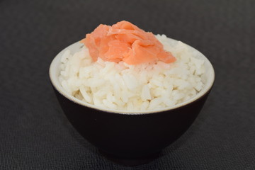 Sushi with salmon in a bowl on a black background.