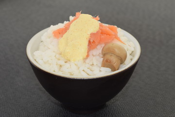Sushi with salmon champignon and sauce in a bowl.