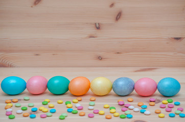 eight easter eggs pastel colored on the wooden background