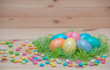 happy easter eggs pastel colored in a nest with candle on the