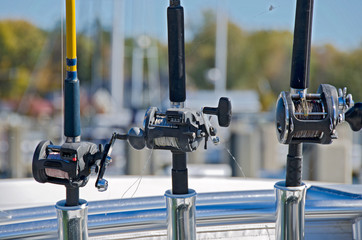 fishing rods and reels in holders on boat
