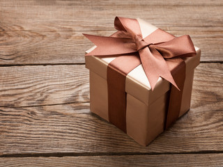 Brown gift box with a bow on the old board. gift concept