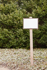 Ein leeres weisses Schild an einem Holzstab