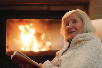 Senior woman relaxing at by fireplace