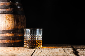Strong alcohol on a wooden table and barrel