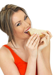 Young Woman Eating a Salmon and Cucumber Brown Bread Sandwich