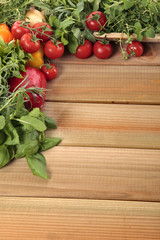 Herbs and vegetables with a blank wooden board for a copyspace