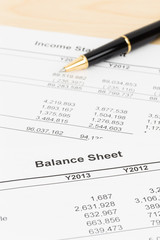 Balance sheet financial report with pen