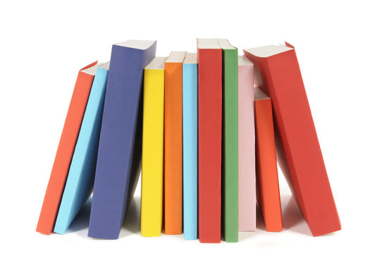 Collection of colorful paperback books in a row line library isolated white background photo
