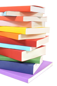 Untidy pile stack of colorful paperback books isolated white background photo