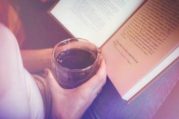 Girl with a cup of tea reading a book