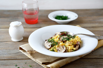 Porridge with mushrooms in white bowl