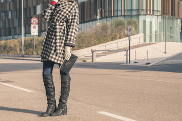 Detail of a young woman posing in the city streets