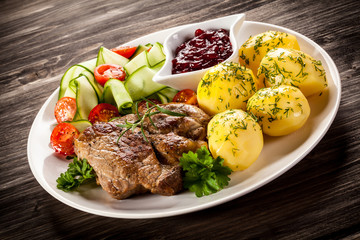 Fried steak, boiled potatoes and vegetable salad
