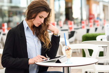 Woman looking at her tablet computer siting in a bar