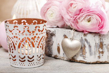 Romantic candle holder and bouquet of pink ranunculus flowers