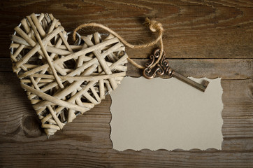 wicker heart handmade with the key lying on a wooden base with a