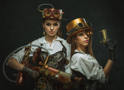 Two girls dressed in the style of steampunk with arms