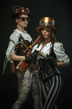 Two girls dressed in the style of steampunk with arms