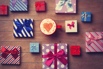 Obraz premium Cup and gift boxes on wooden background