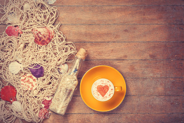 Cup and net with shells and bottle