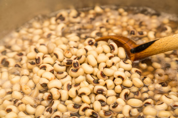 Stirring Black-Eyed Peas in Pot with Wood Spoon
