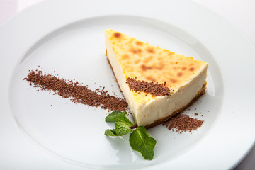 Piece of yellow cake with chocolate frosting and green leaf
