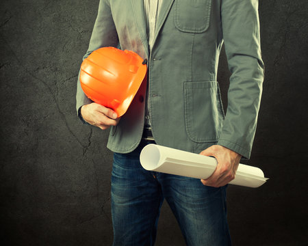 Portrait of construction master holding yellow helmet