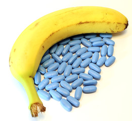 banana with many blue pills for male problems - obrazy, fototapety, plakaty