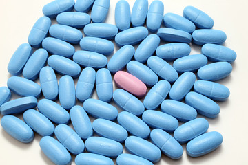 single pink pill among many pads blue