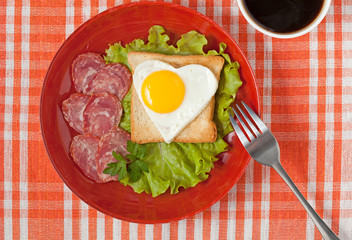 Fried heart shaped egg on toast with salad and coffee for Valent