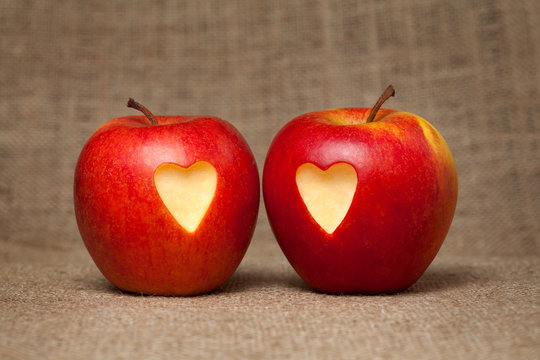 Two apples with hearts on vintage textile background