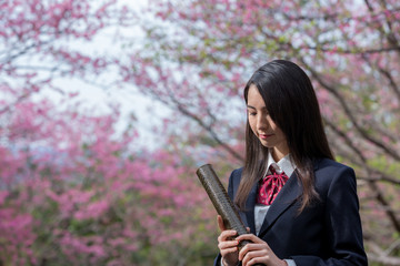 卒業証書の筒を持って笑っている女子学生