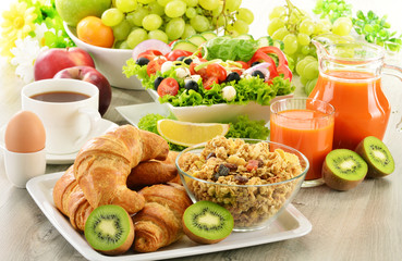 Breakfast with coffee, juice, croissant, salad, muesli and egg