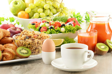 Breakfast with coffee, juice, croissant, salad, muesli and egg
