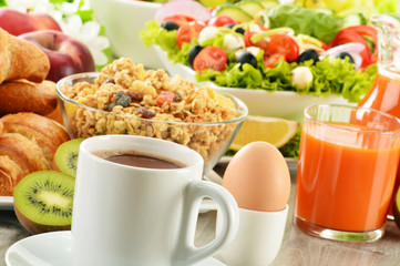 Breakfast with coffee, juice, croissant, salad, muesli and egg