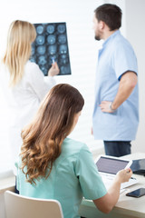 Doctors reading MRI and electrocardiogram
