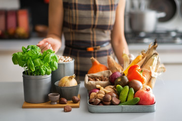 Closeup on young housewife with vegetables in kitchen