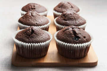 Several chocolate muffins on the wood board