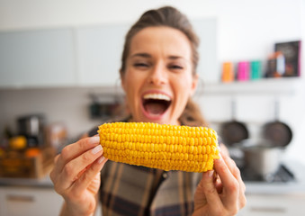 Closeup on young woman eating boiled corn - obrazy, fototapety, plakaty