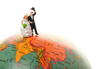 地球儀の上に立っている結婚した二人のカップル