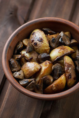 Ceramic bowl with roasted unpeeled potato and mushrooms