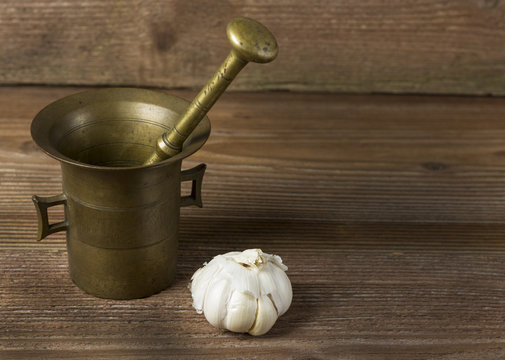Mortar and garlic on wooden background