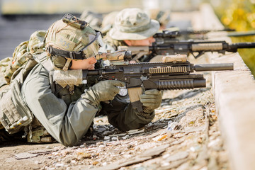 Fototapeta premium group of soldiers lie and shoot