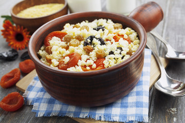 Millet porridge with dried apricots and prunes in a bowl