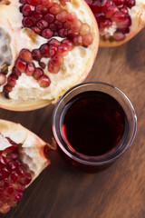 Ripe pomegranates with juice on table