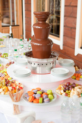 Dessert table whith chocolate machine fountain