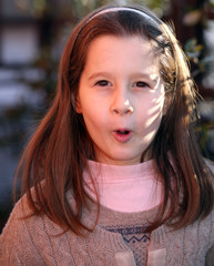 little girl surprised with a wool sweater outdoors