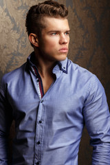 Fashion portrait of man in shirt showing his abs.
