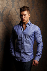 Fashion portrait of man in shirt showing his abs.